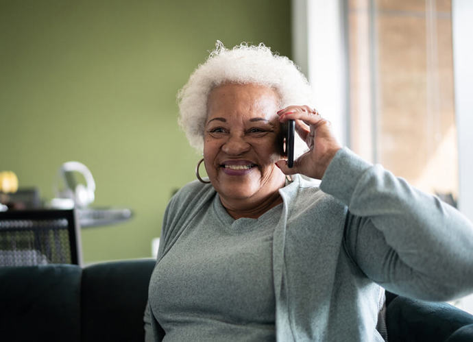 An older woman smiling while speaking on her mobile 